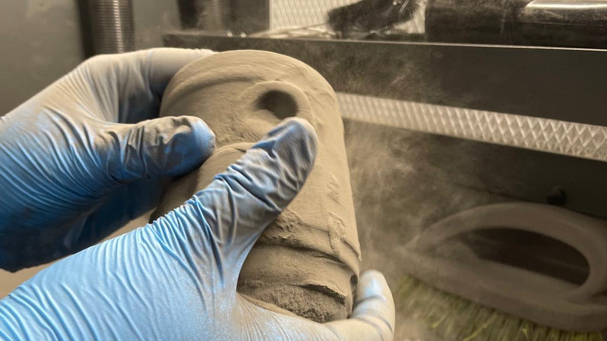 Primo piano di una parte della scocca del bicchiere intelligente Drinky, durante la fase di pulizia, dalla polvere residua, del pezzo stampato in 3D con tecnologia SLS in Nylon 12